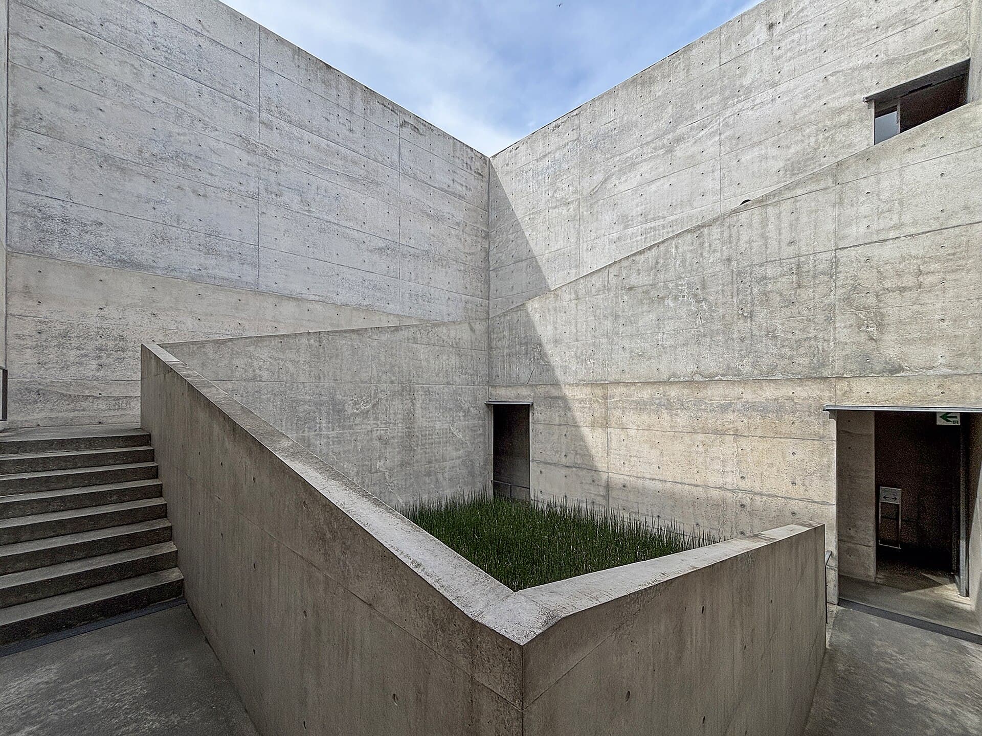 Concrete courtyard with angular light and deep architectural shadow